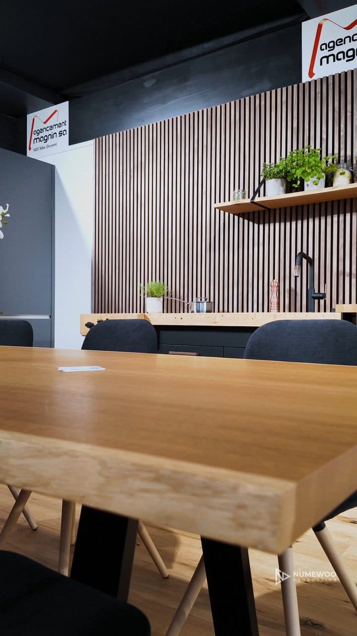 Cuisine en forme d'établi en bois massif avec évier noir, sur le stand d'Agencement Magnin au Comptoir gruérien
